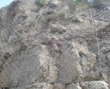 A large piece of slope protection rope mesh is covered on the slope.