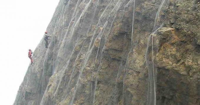 Several workers are installing the slope protection rope mesh.
