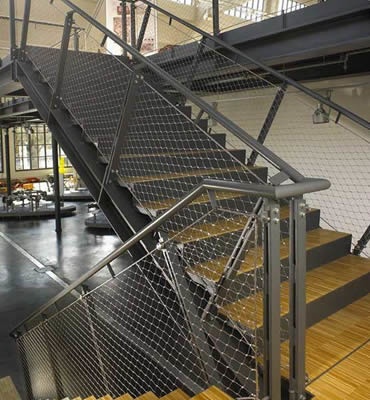 Stainless steel ferrule rope mesh is installed as indoor stair balustrade infill.