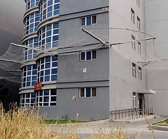 Stainless steel safety net mounted below a high building to protect below pedestrians.